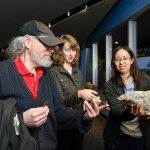 Graduate student Christine Chen (right) shows guests a stalagmite. The mineral is used to understand ancient climate. Credit: John Gillooly